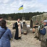 Archpriest Vitaliy Herasymiv praying with soldiers