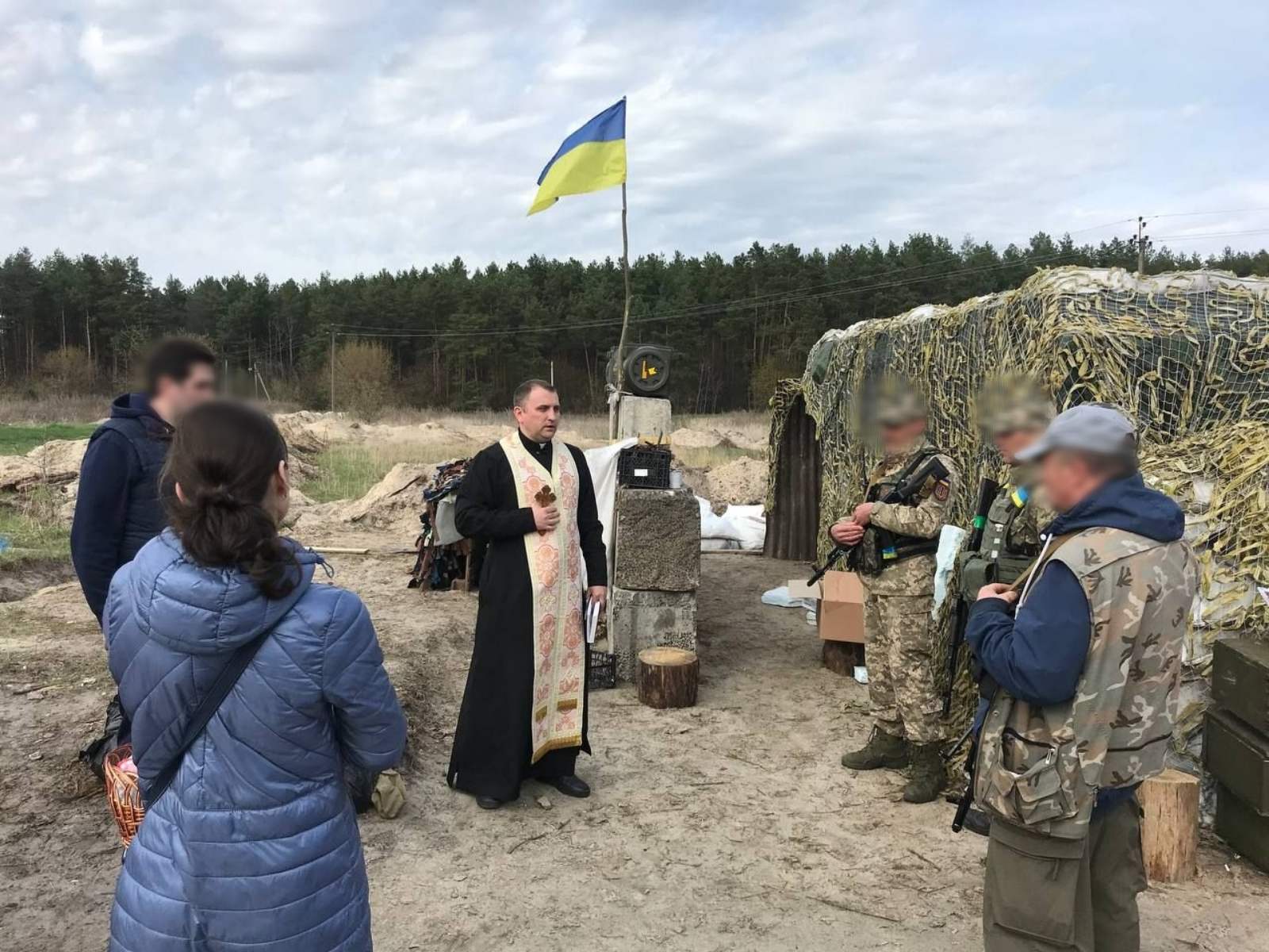 Archpriest Vitaliy Herasymiv praying with soldiers